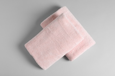 Photo of Soft folded towels on light background, top view