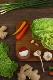 Photo of Flat lay composition with fresh Chinese cabbages and ingredients on wooden table