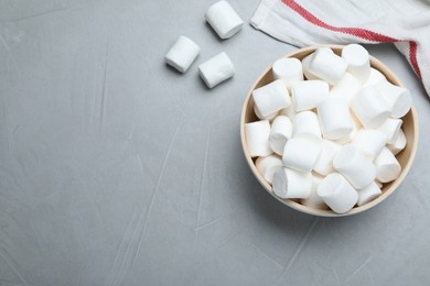 Photo of Delicious puffy marshmallows on grey table, flat lay. Space for text