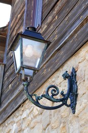Photo of Beautiful old fashioned street lamp on wall of building