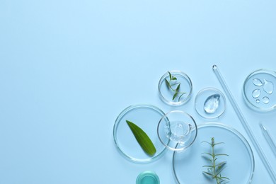 Photo of Organic cosmetic product, natural ingredients and laboratory glassware on light blue background, flat lay. Space for text