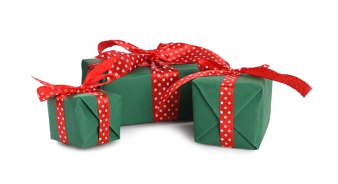 Photo of Christmas gift boxes decorated with red bows on white background