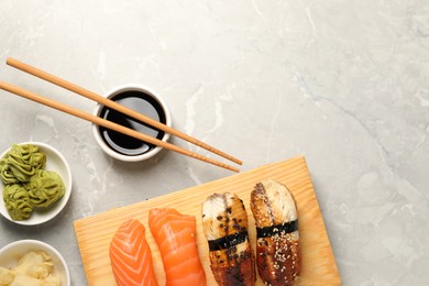 Photo of Delicious nigiri sushi served on light grey marble table, flat lay. Space for text