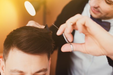 Image of Professional hairdresser working with client in beauty salon, closeup