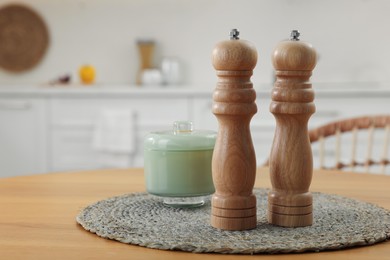 Photo of Wooden salt and pepper shakers on table in kitchen, space for text
