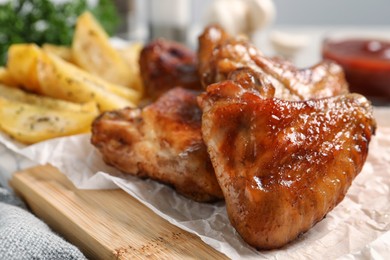 Photo of Delicious fried chicken wings served on table, closeup