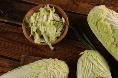 Photo of Whole and cut fresh Chinese cabbages on wooden table