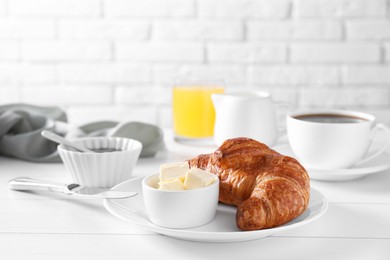 Photo of Fresh croissant and butter on white wooden table. Tasty breakfast