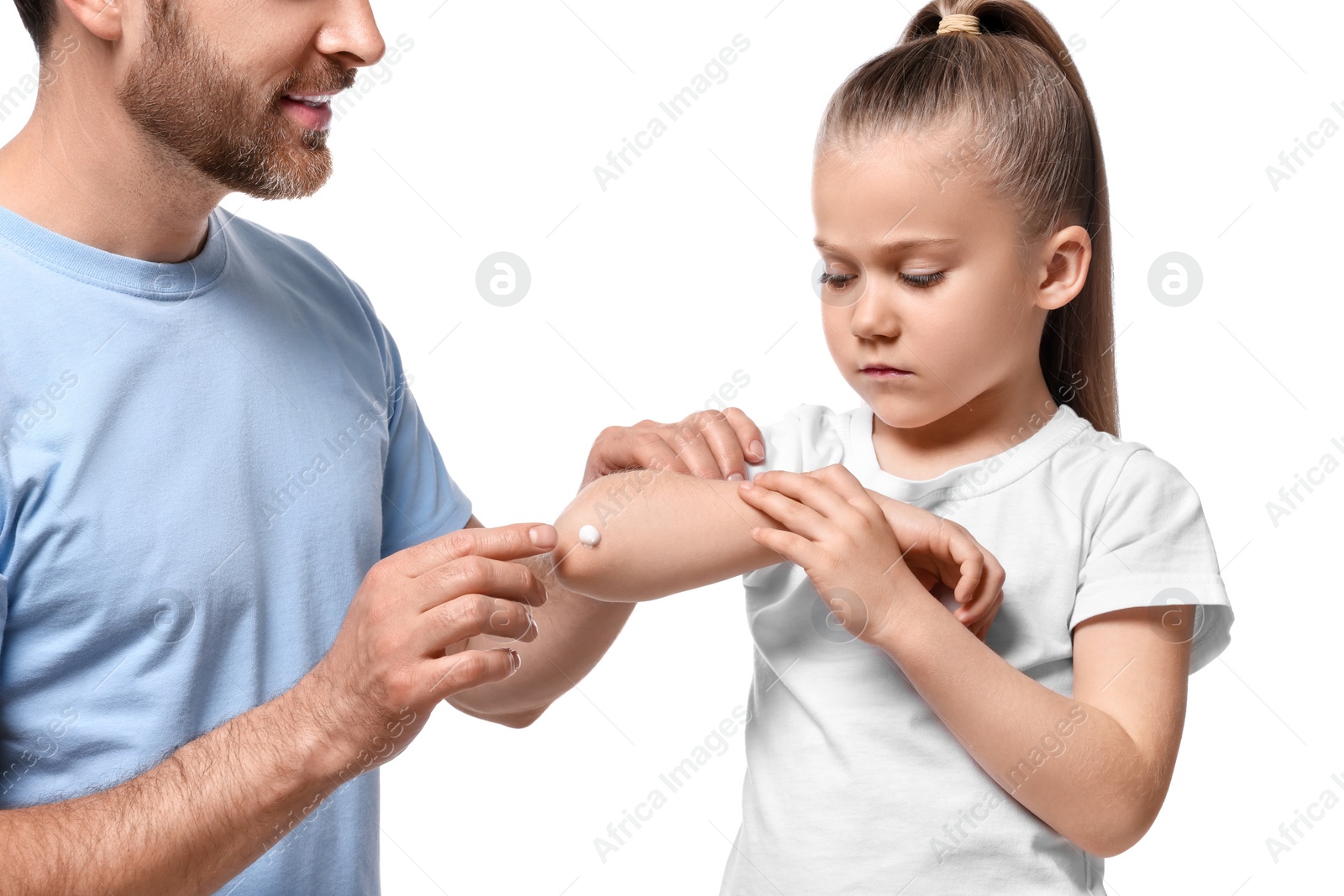 Photo of Father applying ointment onto his daughter's elbow on white background