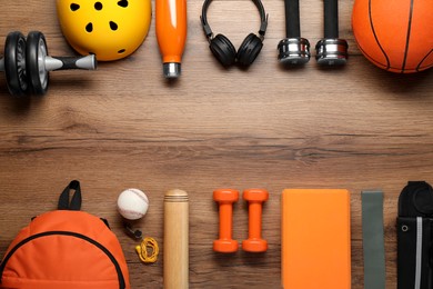 Photo of Frame made of different sports equipment on wooden table, flat lay. Space for text