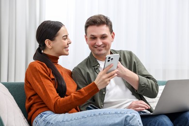 Photo of Happy couple with credit card and gadgets shopping online at home