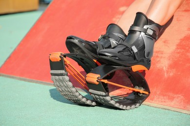 Photo of Woman with kangoo jumping boots outdoors, closeup