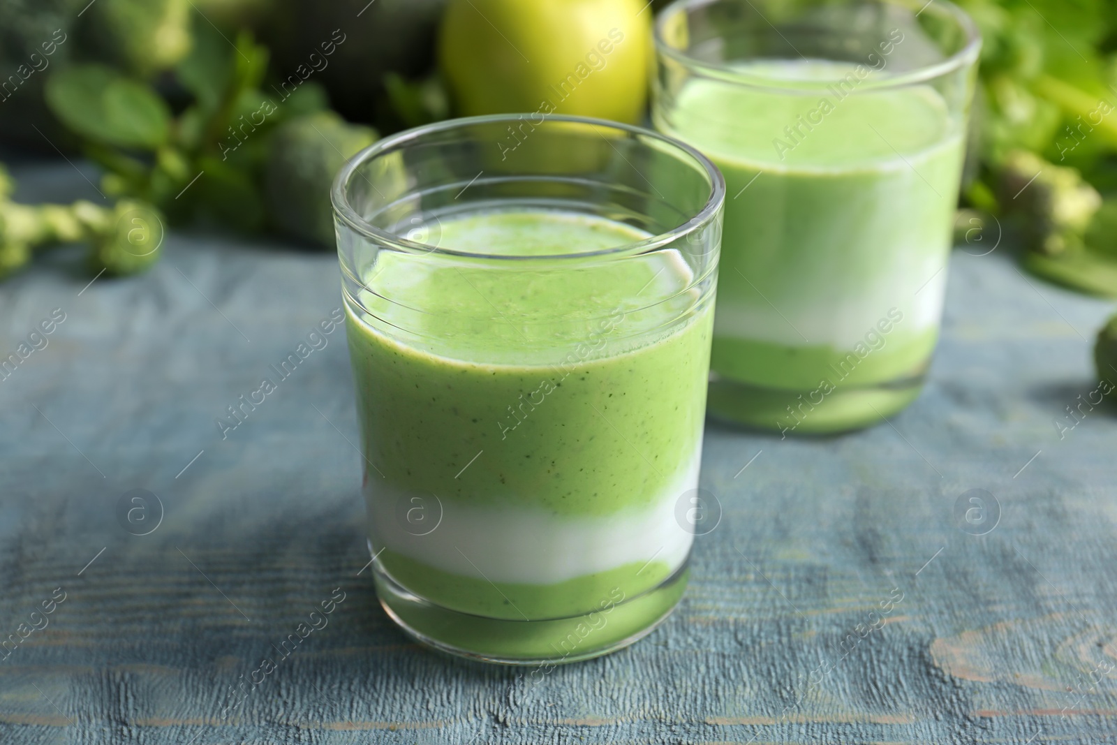 Photo of Glasses with healthy detox smoothie and ingredients on table