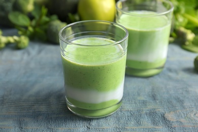 Photo of Glasses with healthy detox smoothie and ingredients on table