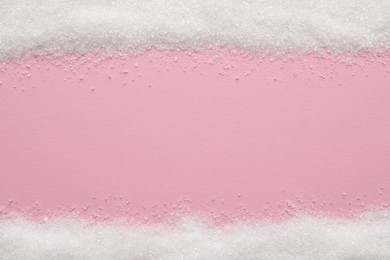 Photo of Granulated sugar on pink background, top view. Space for text
