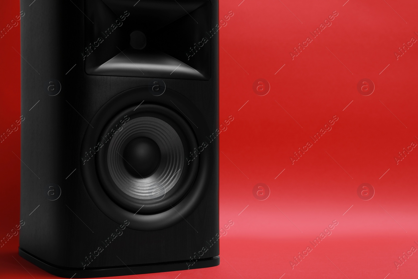 Photo of One wooden sound speaker on red background, closeup. Space for text