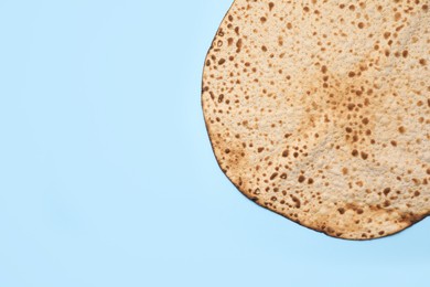 Photo of Tasty matzo on light blue background, top view with space for text. Passover (Pesach) celebration