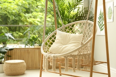 Photo of Comfortable hammock chair in stylish room. Home interior