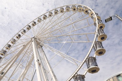 Photo of Beautiful Ferris wheel against cloudy sky, low angle view