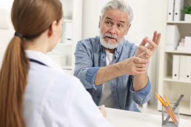 Photo of Arthritis symptoms. Doctor consulting patient with wrist pain in hospital