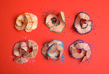 Photo of Pencil shavings on red background, flat lay
