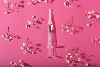Photo of Cosmetology. Medical syringe and gypsophila flowers on pink background, flat lay