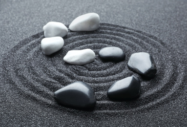 Photo of Stones on black sand with beautiful pattern. Zen and harmony