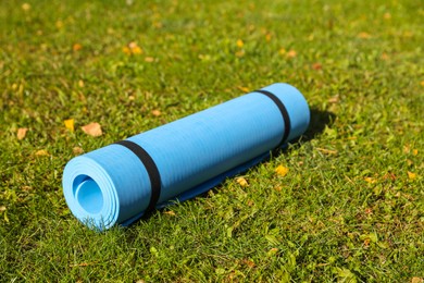 Photo of Blue karemat or fitness mat on fresh green grass outdoors