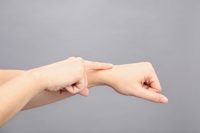 Photo of Woman showing word time on grey background, closeup. Sign language