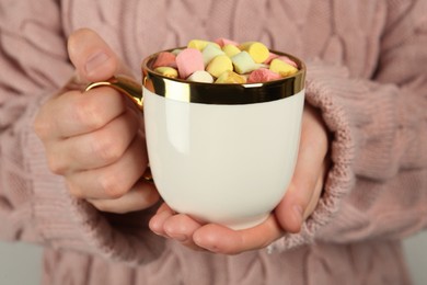 Photo of Woman holding cup of delicious hot chocolate with marshmallows, closeup