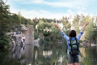 Photo of Young woman near lake and forest. Camping season