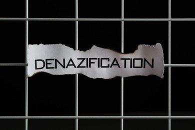 Photo of Paper with word Denazification on lattice against black background