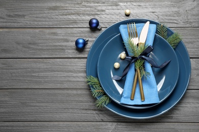 Photo of Christmas table setting on grey wooden background, flat lay. Space for text