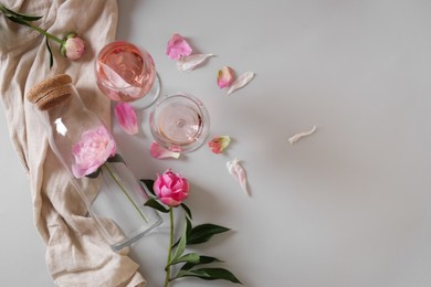 Photo of Flat lay composition with rose wine and beautiful pink peonies on white background. Space for text