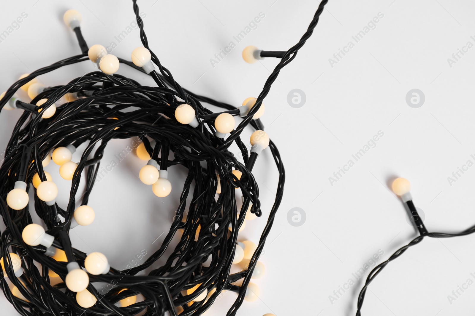 Photo of Beautiful Christmas lights on white background, top view