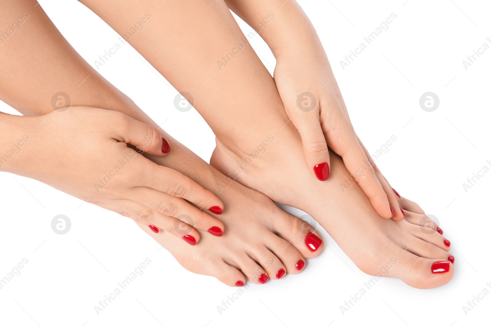 Photo of Woman showing stylish toenails after pedicure procedure and manicured hands with red nail polish isolated on white, closeup