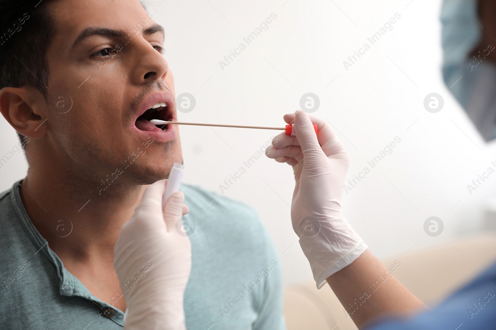 Photo of Doctor taking sample for DNA test from man in clinic