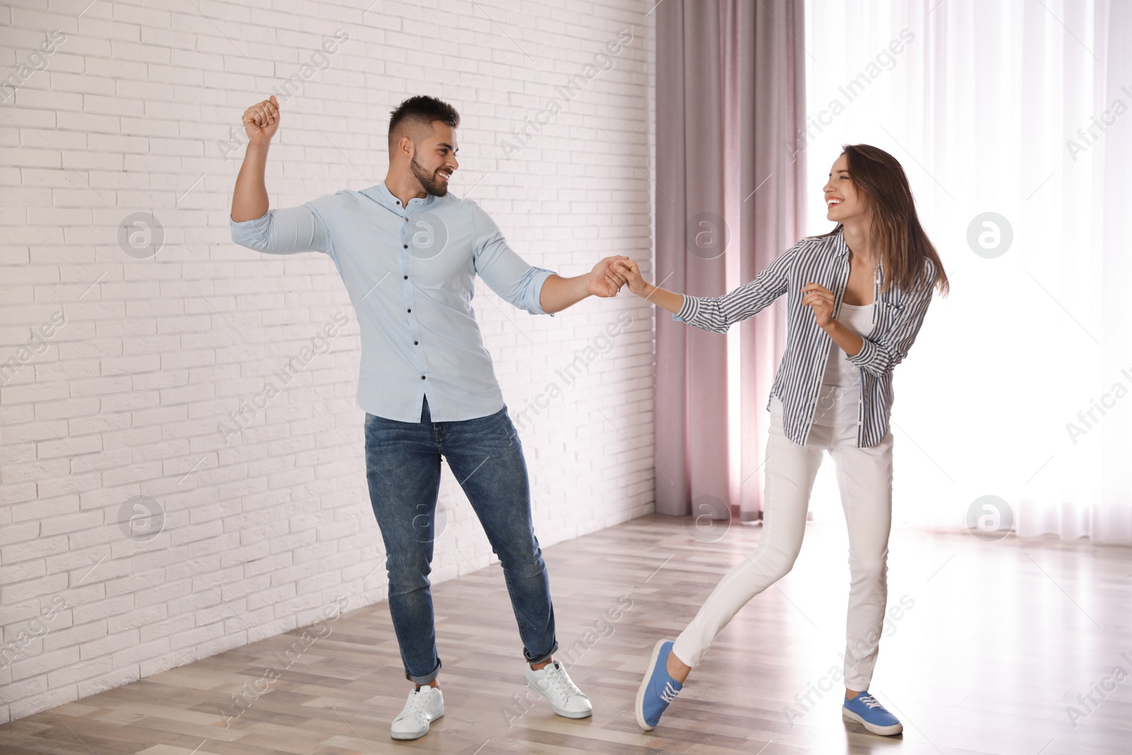 Photo of Lovely young couple dancing together at home