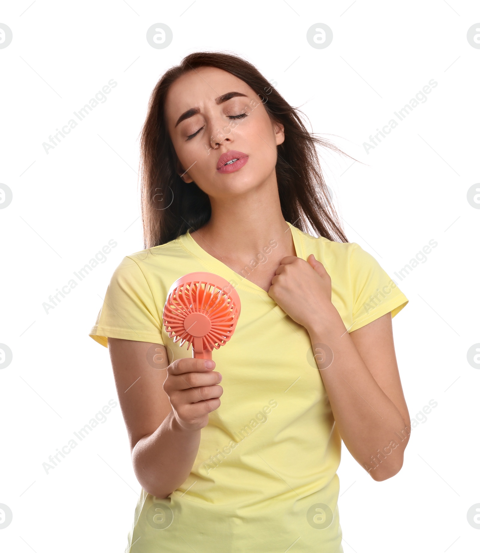 Photo of Woman with portable fan suffering from heat on white background. Summer season