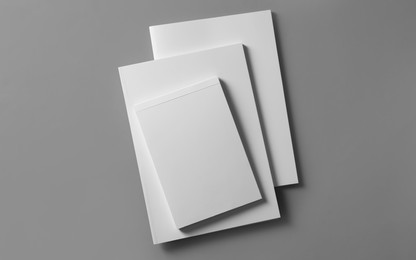 Photo of Brochures with blank covers on light grey background, top view