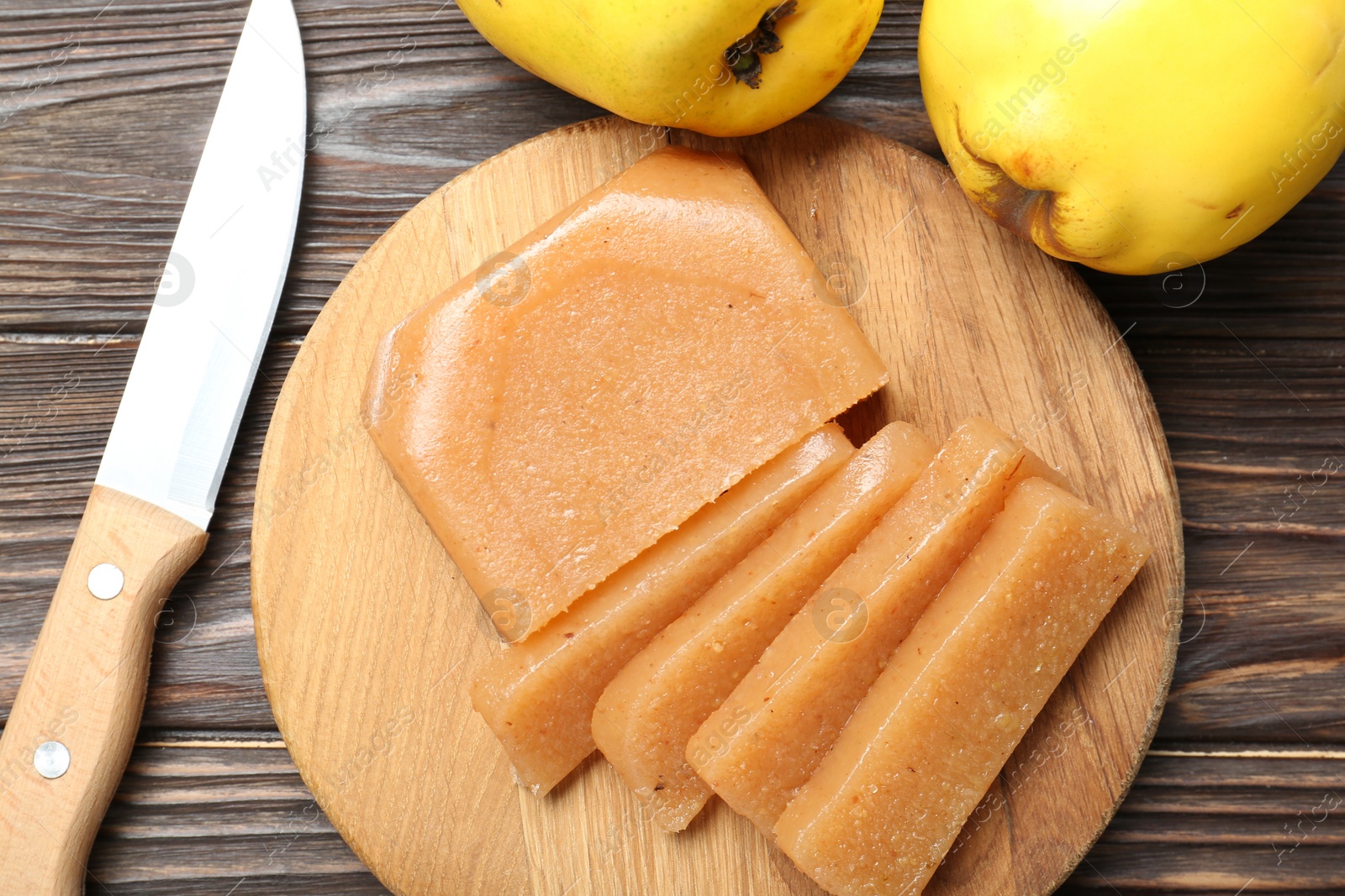 Photo of Tasty sweet quince paste, fresh fruits and knife on wooden table, flat lay