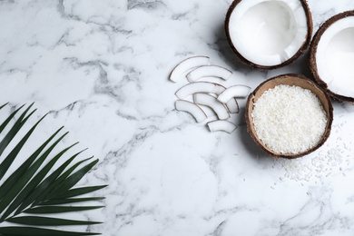 Photo of Flat lay composition with fresh coconut flakes on white marble table. Space for text