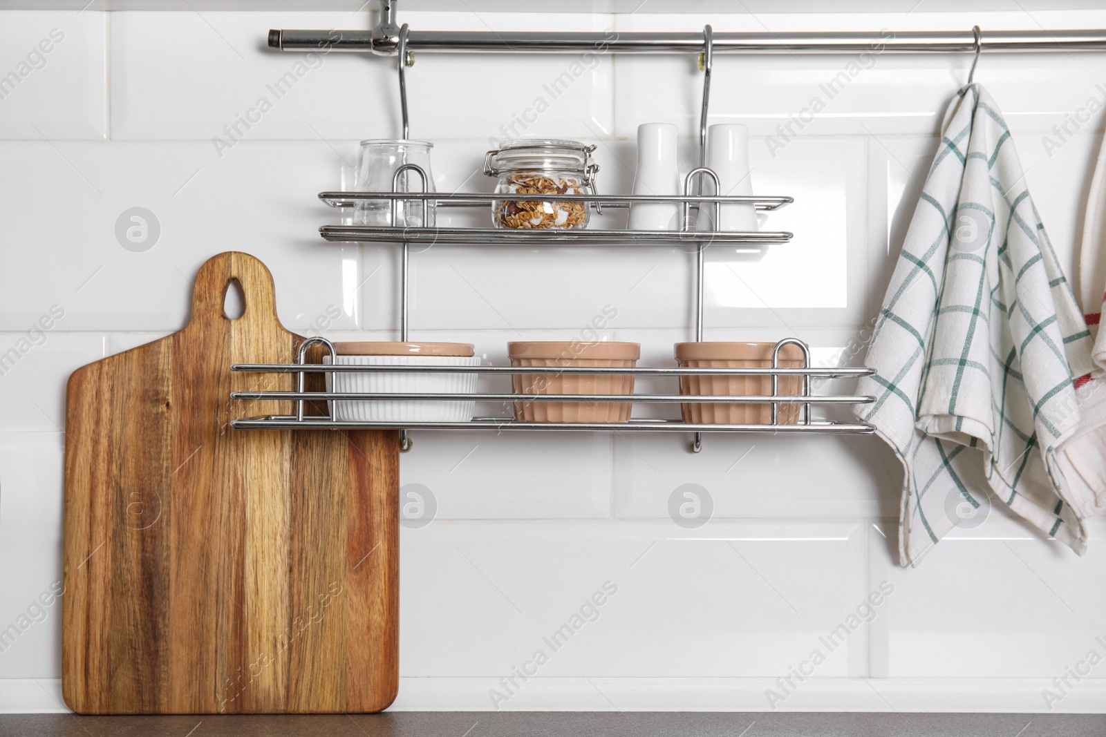 Photo of Kitchen towel hanging on hook rod and shelves with ramekins indoors