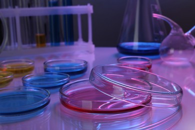 Petri dishes with different colorful samples on table, color toned