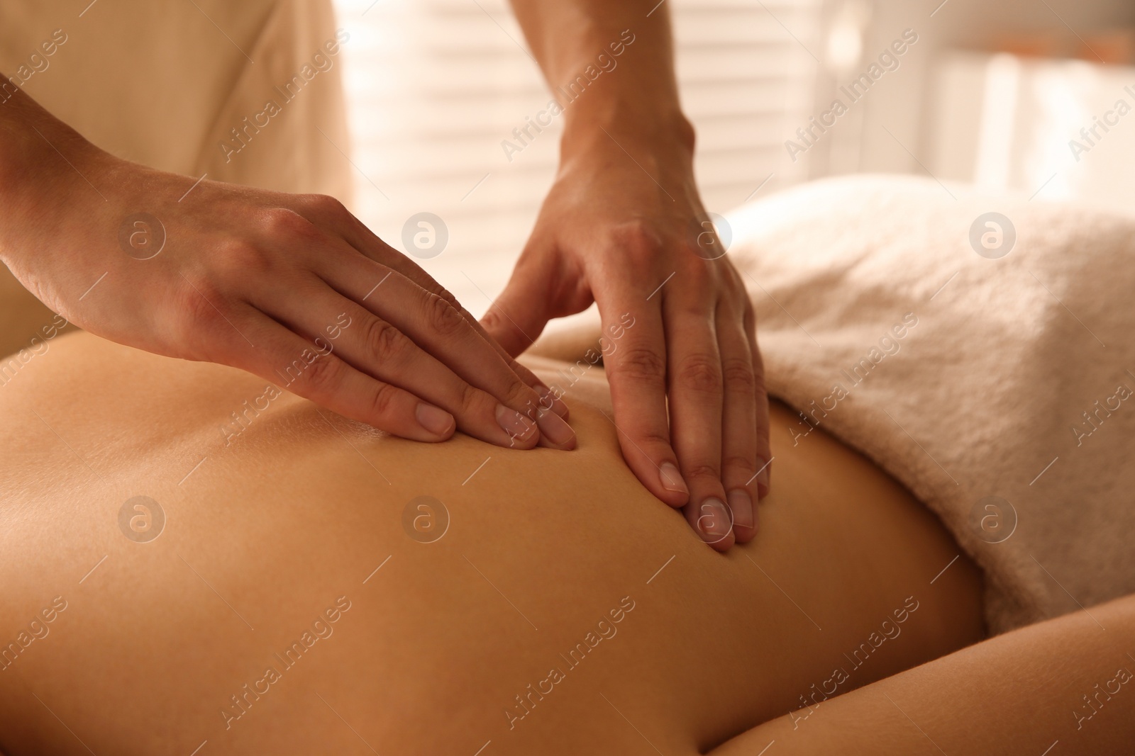 Photo of Young woman receiving back massage in spa salon, closeup