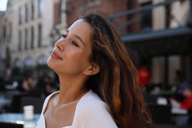 Photo of Portrait of happy young woman on city street