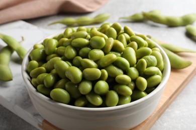 Photo of Bowl of delicious edamame beans on table, closeup