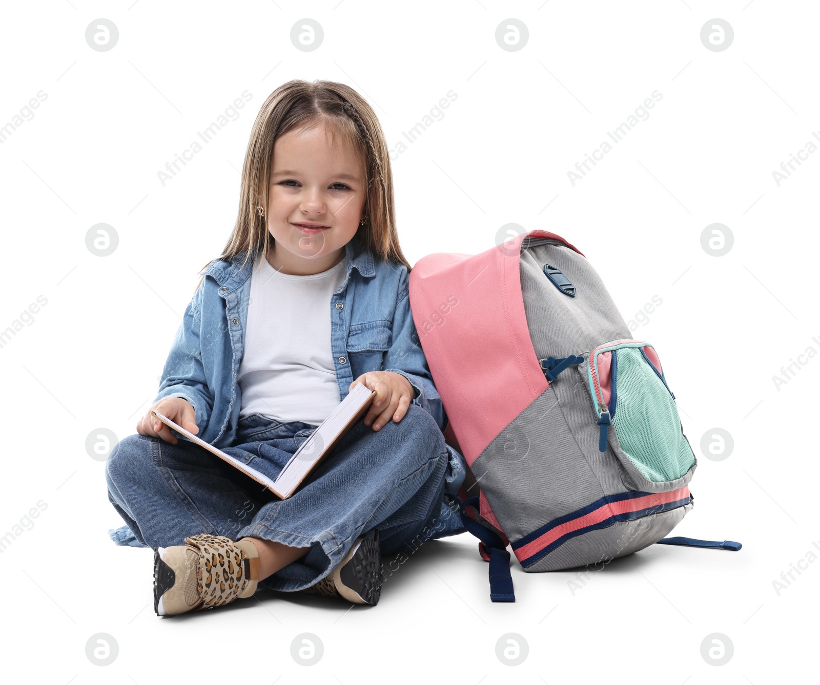 Photo of Cute little girl with book and backpack on white background