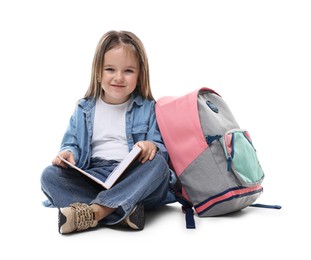 Cute little girl with book and backpack on white background