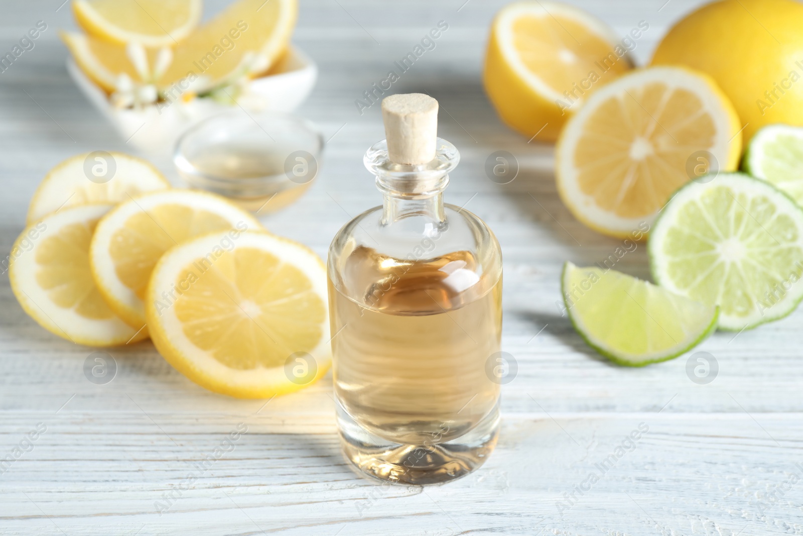 Photo of Citrus essential oil on white wooden table